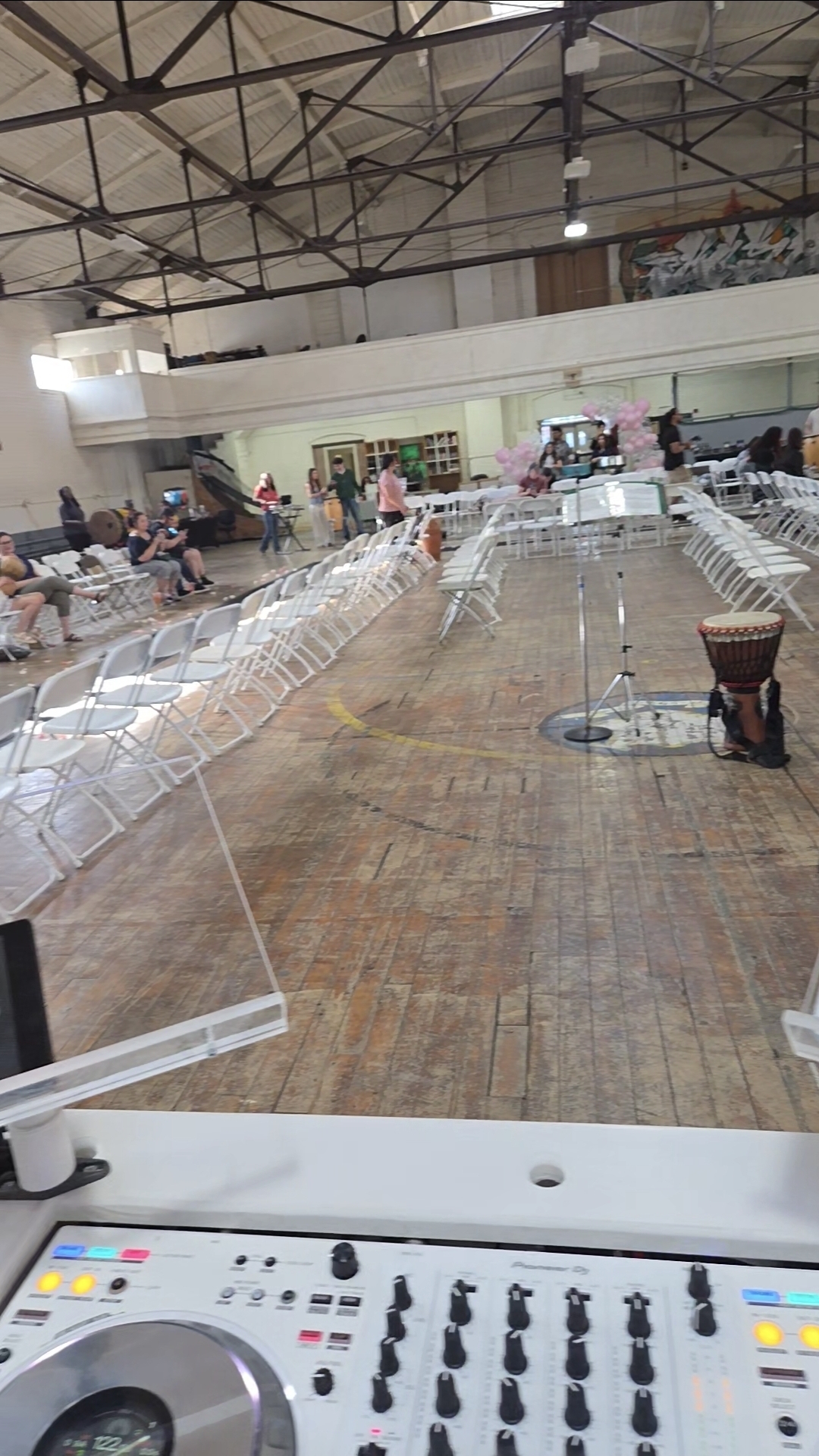 Wide interior of a community hall set with chairs and DJ equipment before a fundraiser program begins