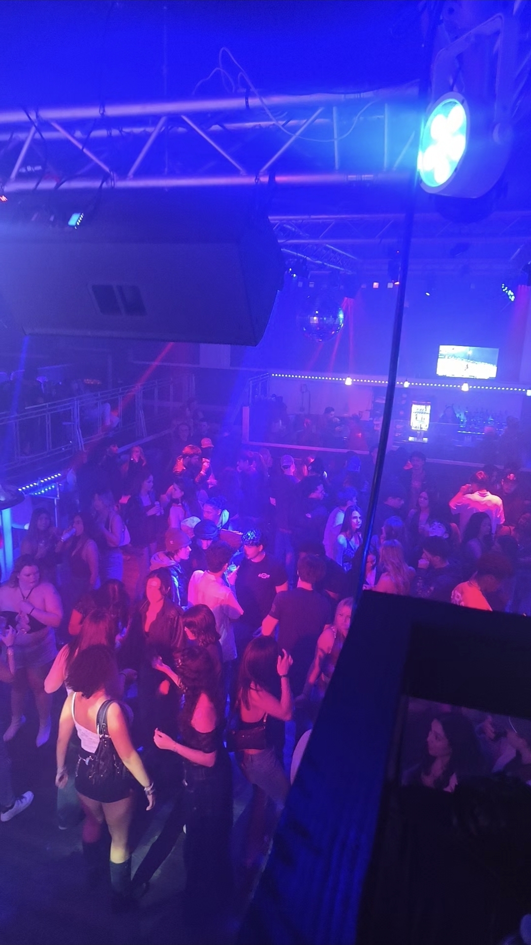 Nightlife performance with packed dance floor and stage lighting