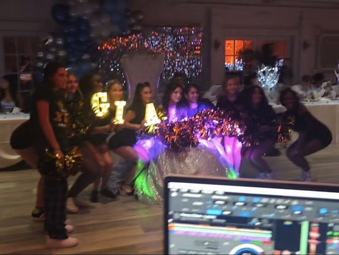 Quinceañera and friends posing with light-up 'GIA' marquee letters and pom-poms