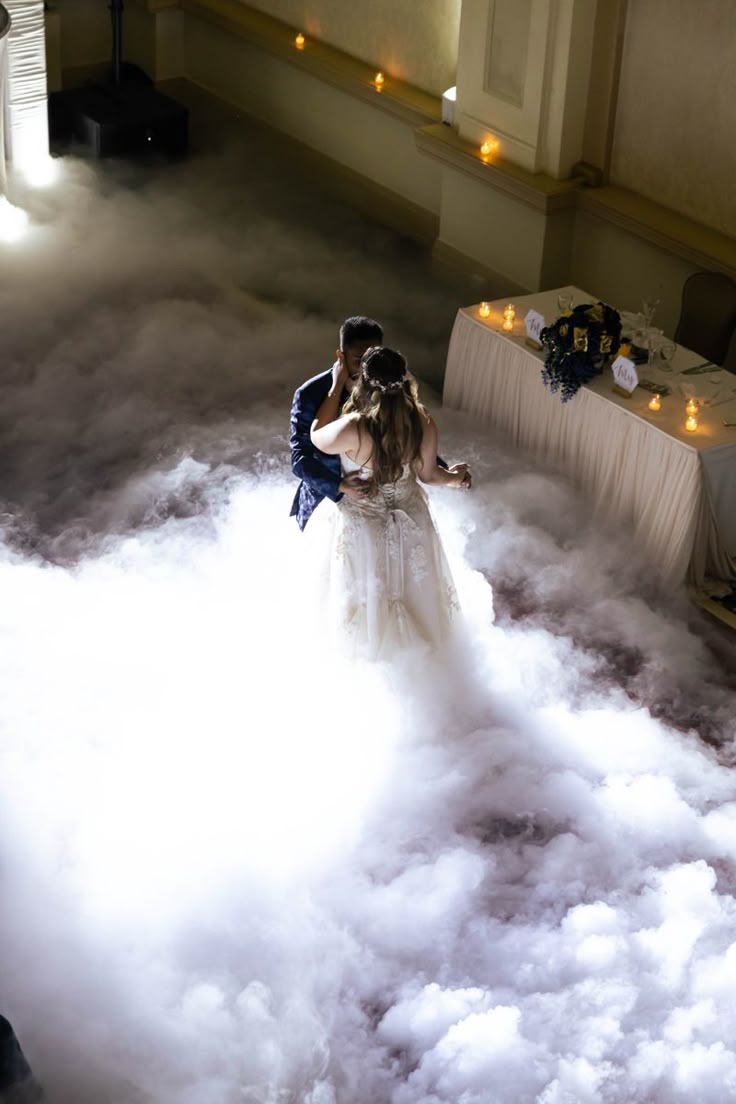 Bride and groom sharing their first dance surrounded by low-lying fog